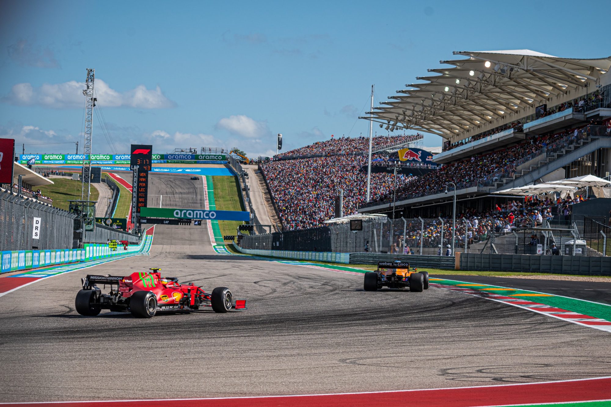 Ferrari and McLaren racing past the packed grandstand at Circuit of the Americas